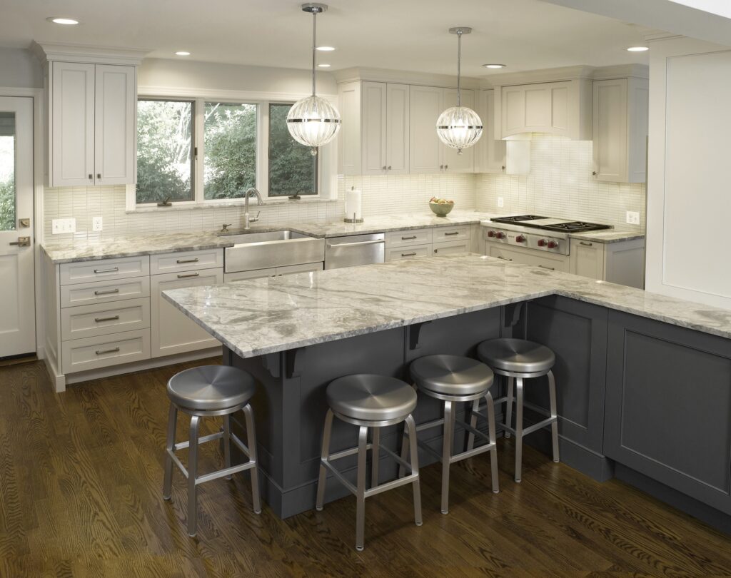 Kitchen with marble island and white cabinets by Hofmann Design Build in New Jersey.